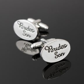 silver oval shaped cufflinks with brides son written in black cursive and debossed in the metal