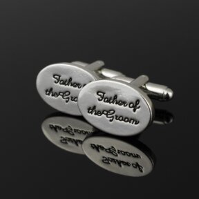 silver oval shaped cufflinks with father of the groom written in black cursive and debossed into the metal