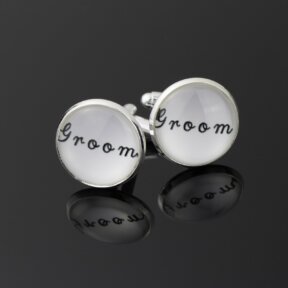round white cufflink with groom written in black cursive